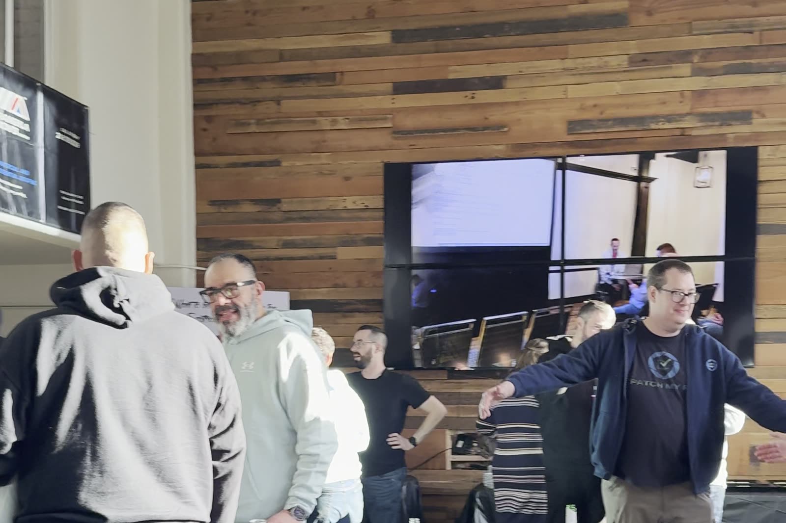 A company event in the Main Hall at 1712 Studios, guests talking in front of the screen