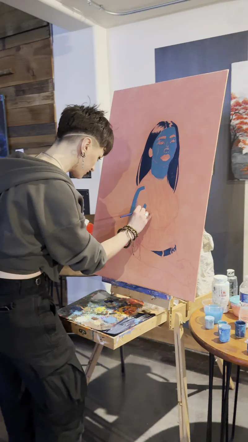 An artist painting a canvas live during a party in the Back Venue at 1712 Studios