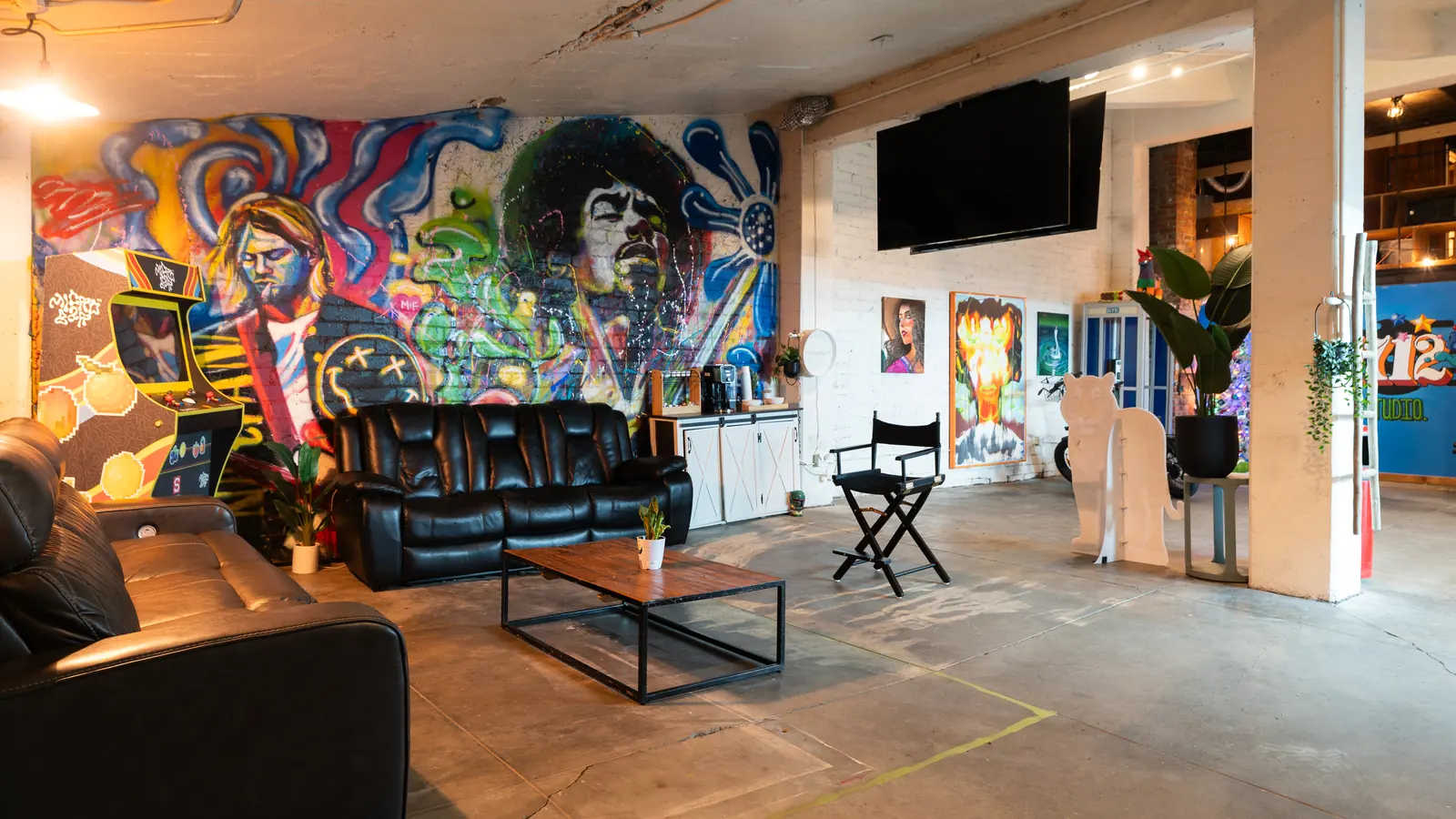 Black leather couches in front of a large graffiti mural in the Back Venue lounge at 1712 Studios