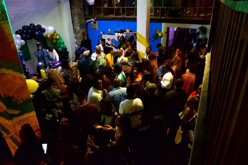 A packed dance floor under the mural and balloon arch in the Back Venue at 1712 Studios