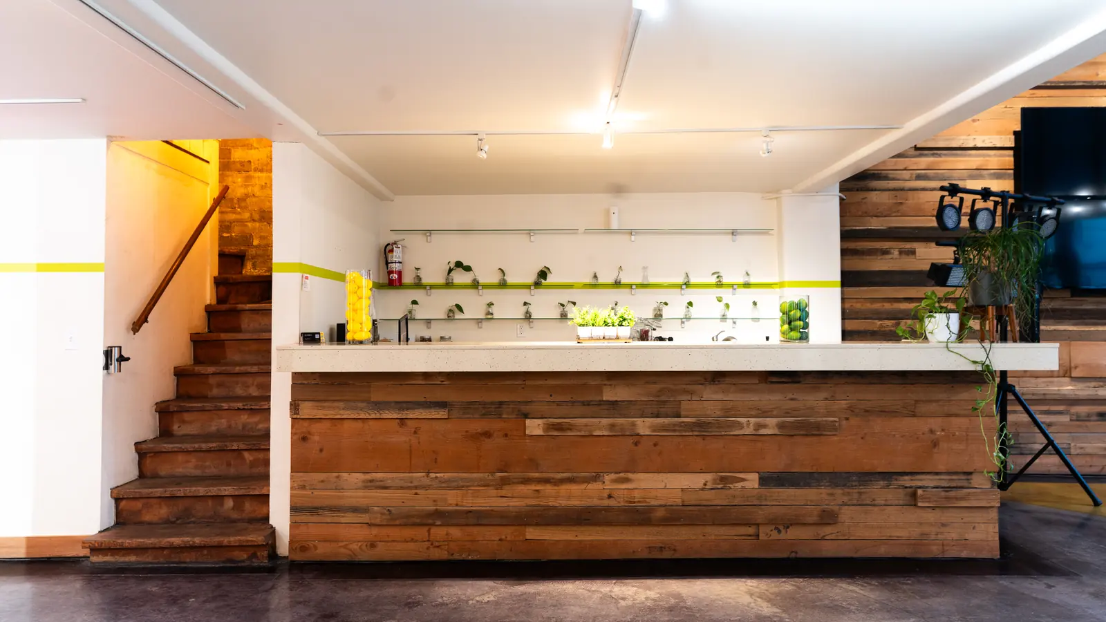 The reclaimed wood bar in the Main Hall at 1712 Studios beside the staircase up to the Speakeasy
