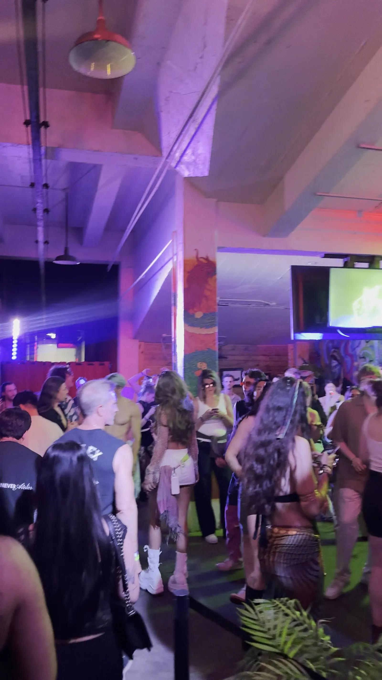 A full dance floor under purple light in the Back Venue at 1712 Studios
