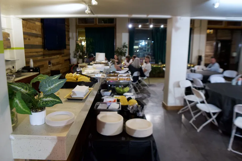 A dinner buffet laid out along the counter in the Main Hall at 1712 Studios with guests seated behind