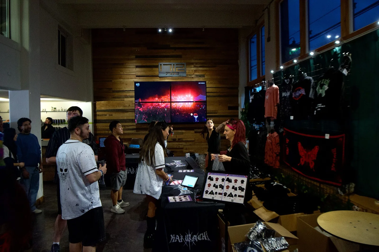 Shoppers at a merch pop up by the 1712 logo wall in the Main Hall at 1712 Studios