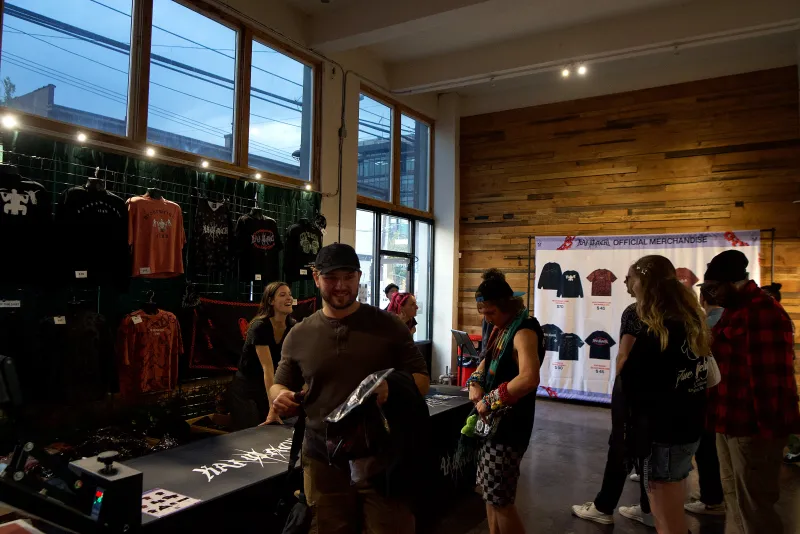 Shoppers browsing merch tables along the wood wall in the Main Hall at 1712 Studios on a pop up day