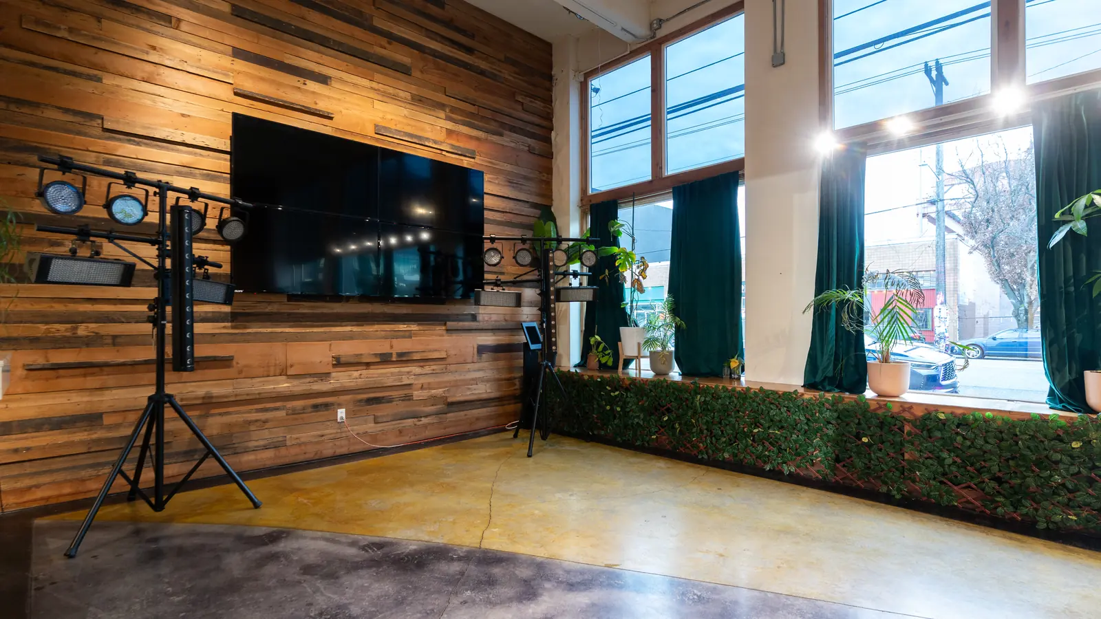 The 110 inch screen and stage lighting on the reclaimed wood wall in the Main Hall at 1712 Studios