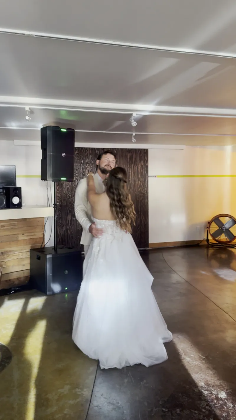 A couple in a first dance by the wood wall in the Main Hall at 1712 Studios