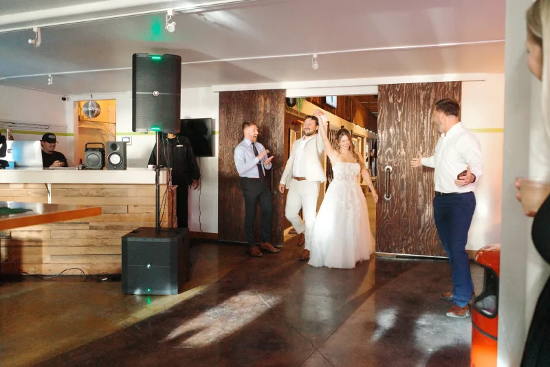 A bride and groom making their entrance through the barn doors into the Main Hall at 1712 Studios, photo by Megan Roling