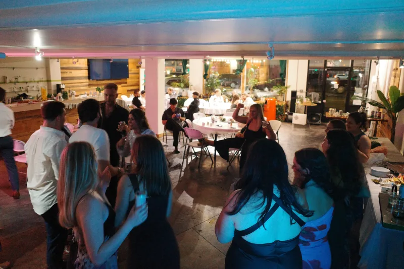 Wedding guests mingling by the tables in the Main Hall at 1712 Studios, photo by Megan Roling